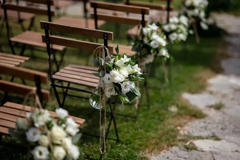 Ceremony chairs with white flowers in the Tuscan countryside, photo Andrea Corsi