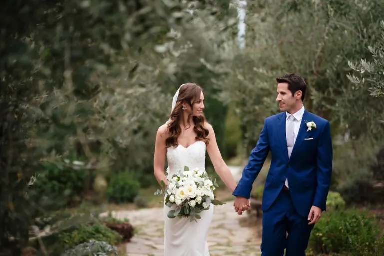 Bride and groom walking among the olive trees, photo Andrea Corsi