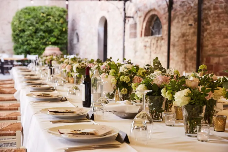 Long wedding table with flowers in the hamlet courtyard