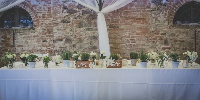 Wedding table set against an old stone wall