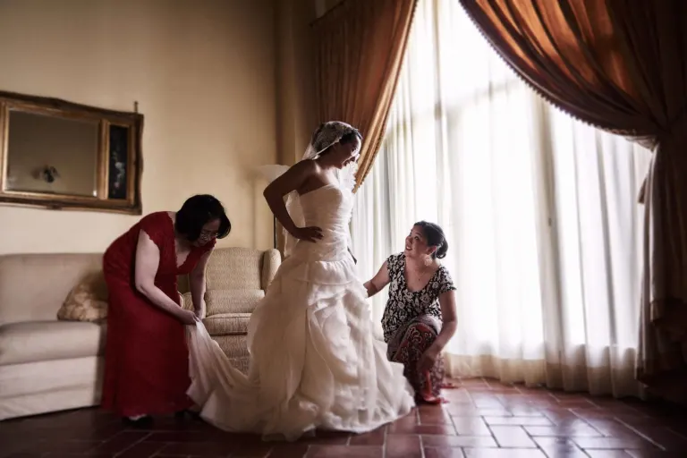 Bridesmaids getting the bride ready in a Tuscan villa