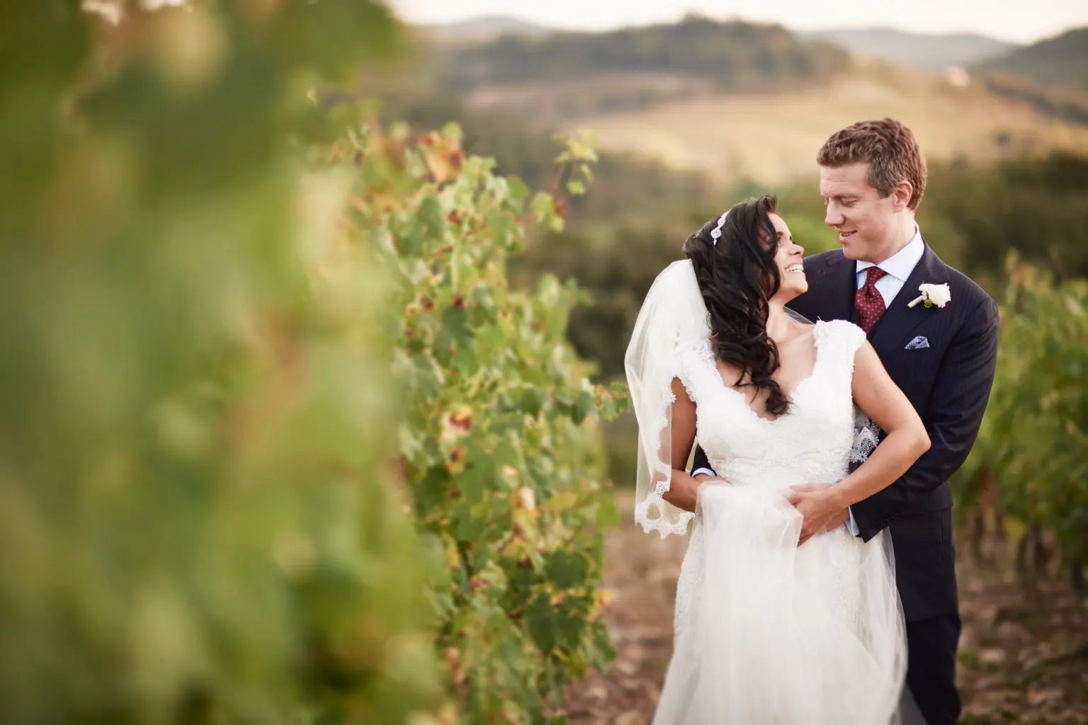 Bride and groom embracing in a vineyard in Tuscany
