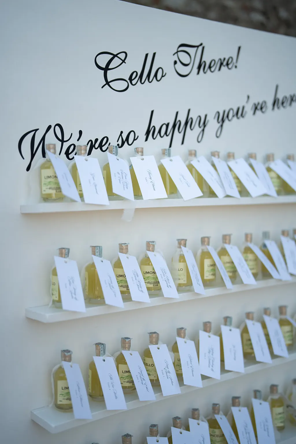 Your guests, Welcome wall with limoncello bottles and place cards for the guests at Castello di Meleto
