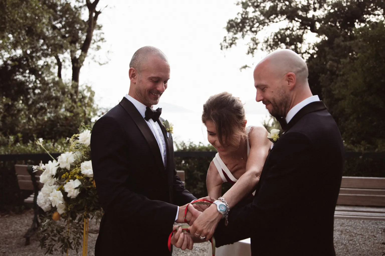 Your ceremony, Two grooms during a handfasting ritual at their symbolic ceremony