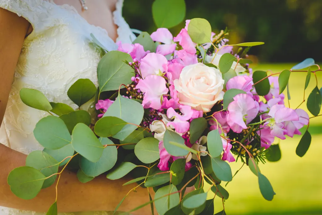 Wedding flowers Bridal bouquet of pink sweet peas, cream roses and eucalyptus held by the bride, photo Simone Miglietta