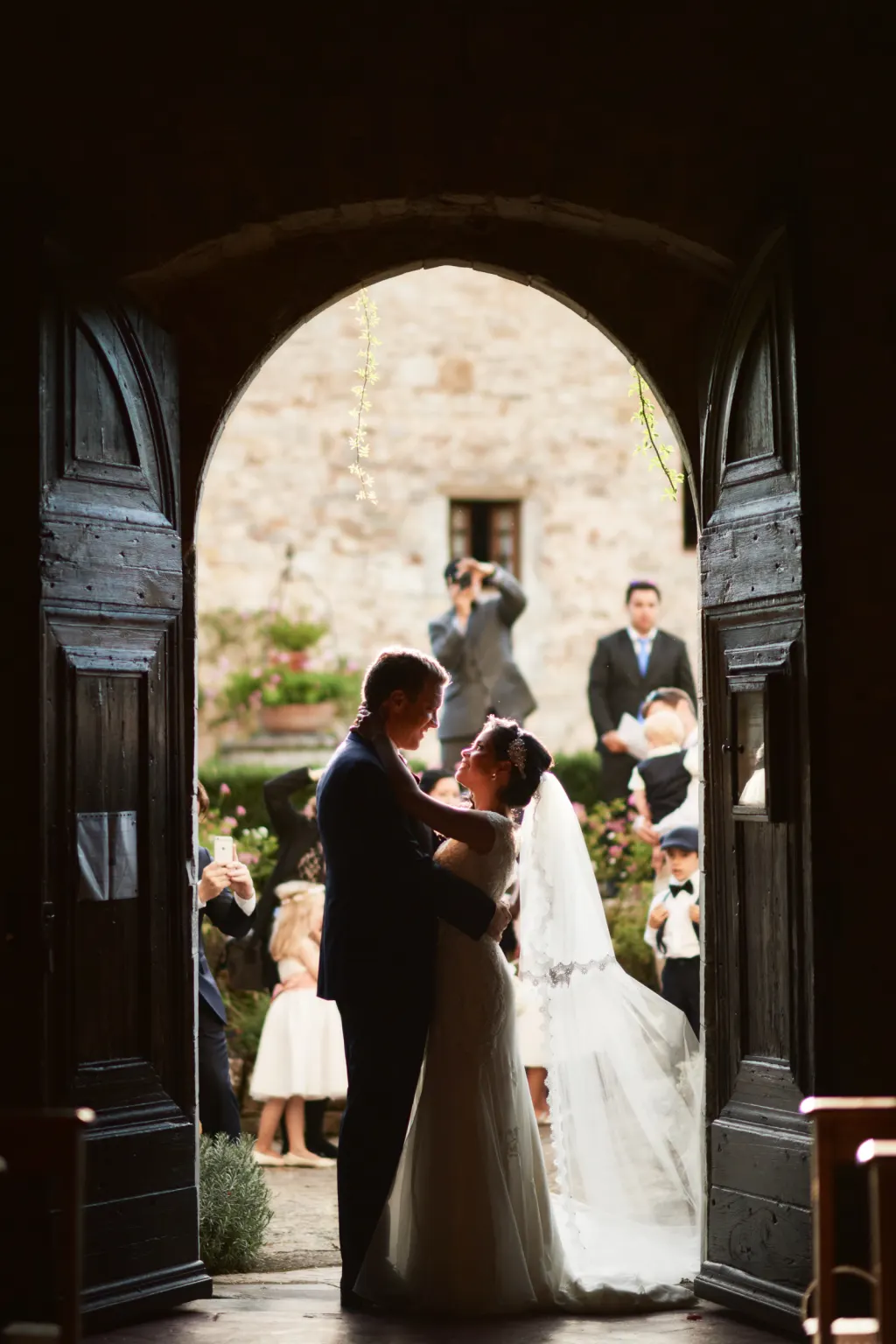 Bride and groom at their ceremony seen through a castle doorway in Chianti