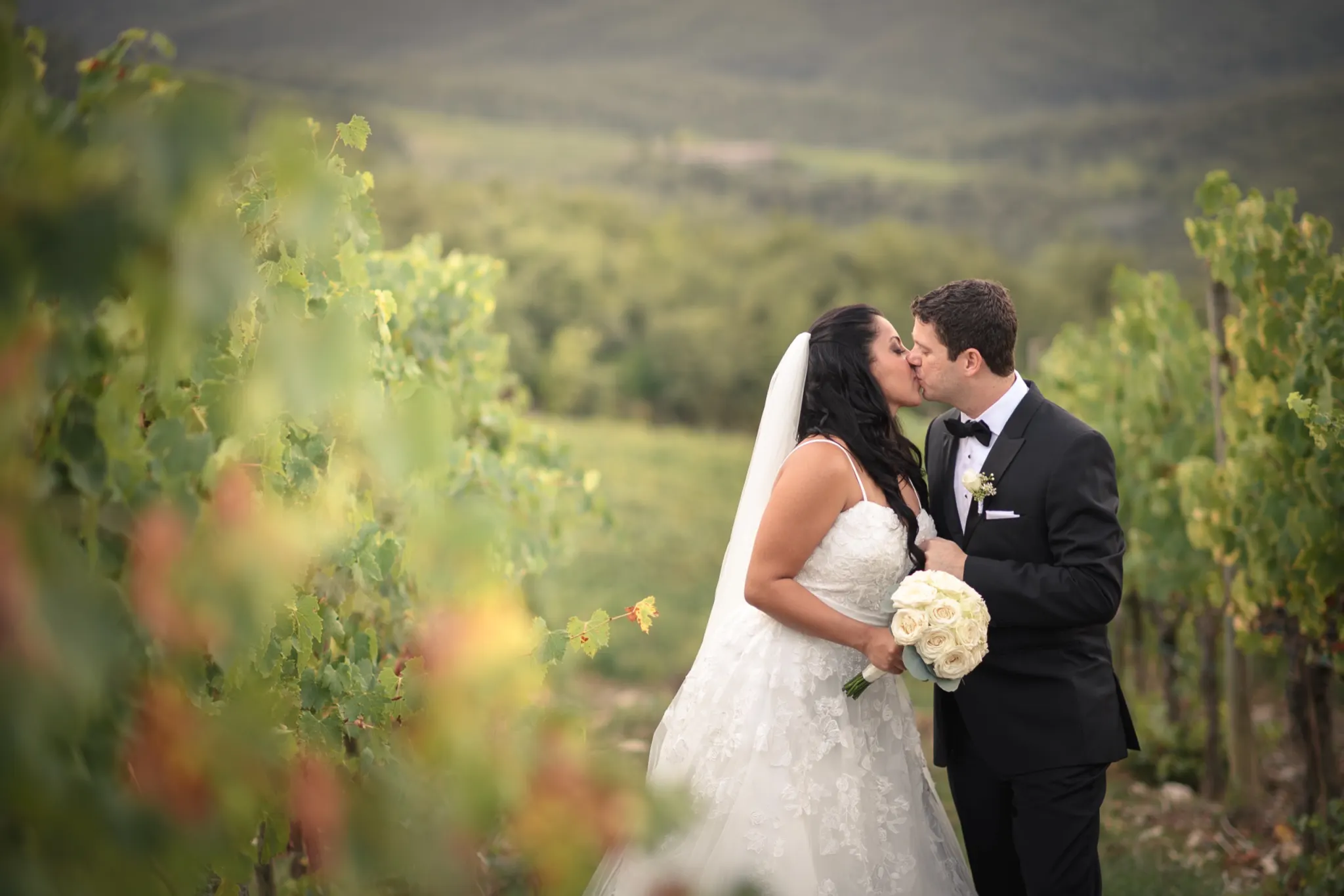 Efffetti® Wedding Planners In Tuscany - Italy Bride and groom kissing among the vines in Chianti