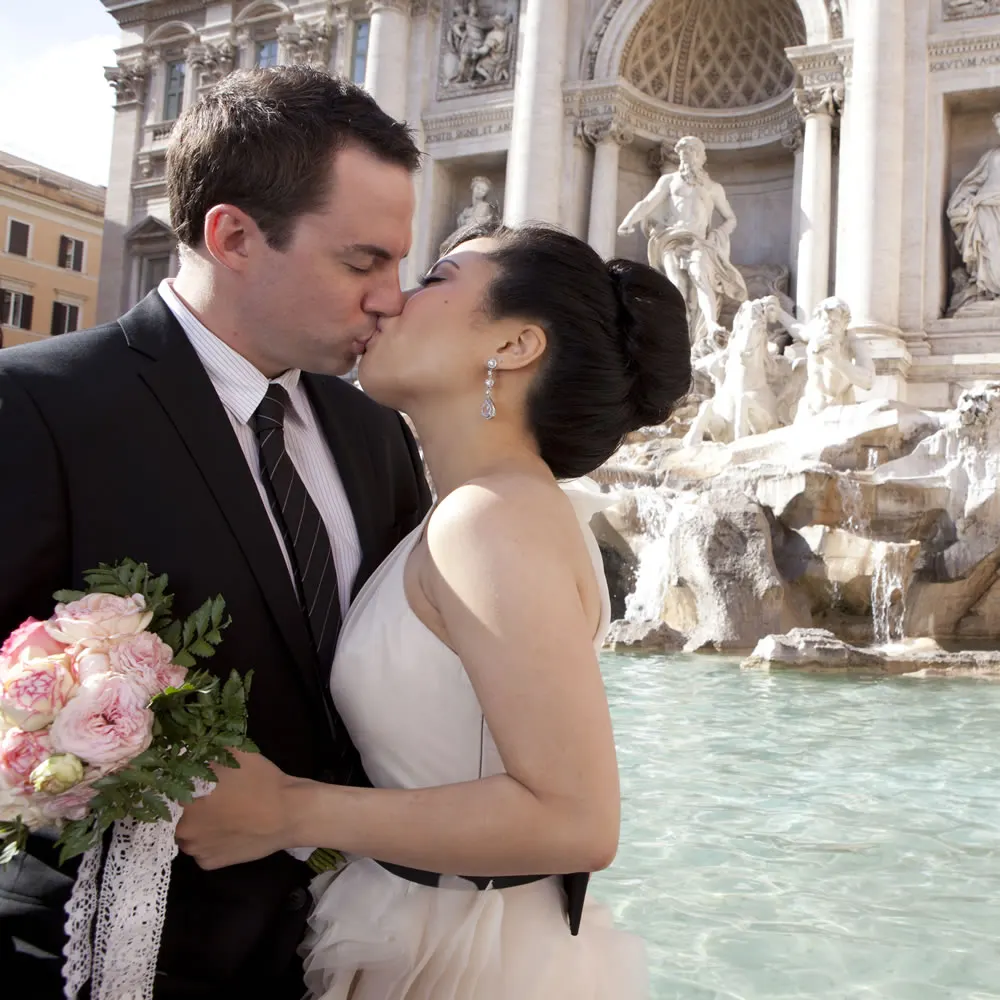 Getting married in Rome Bride and groom kissing in front of the Trevi Fountain in Rome