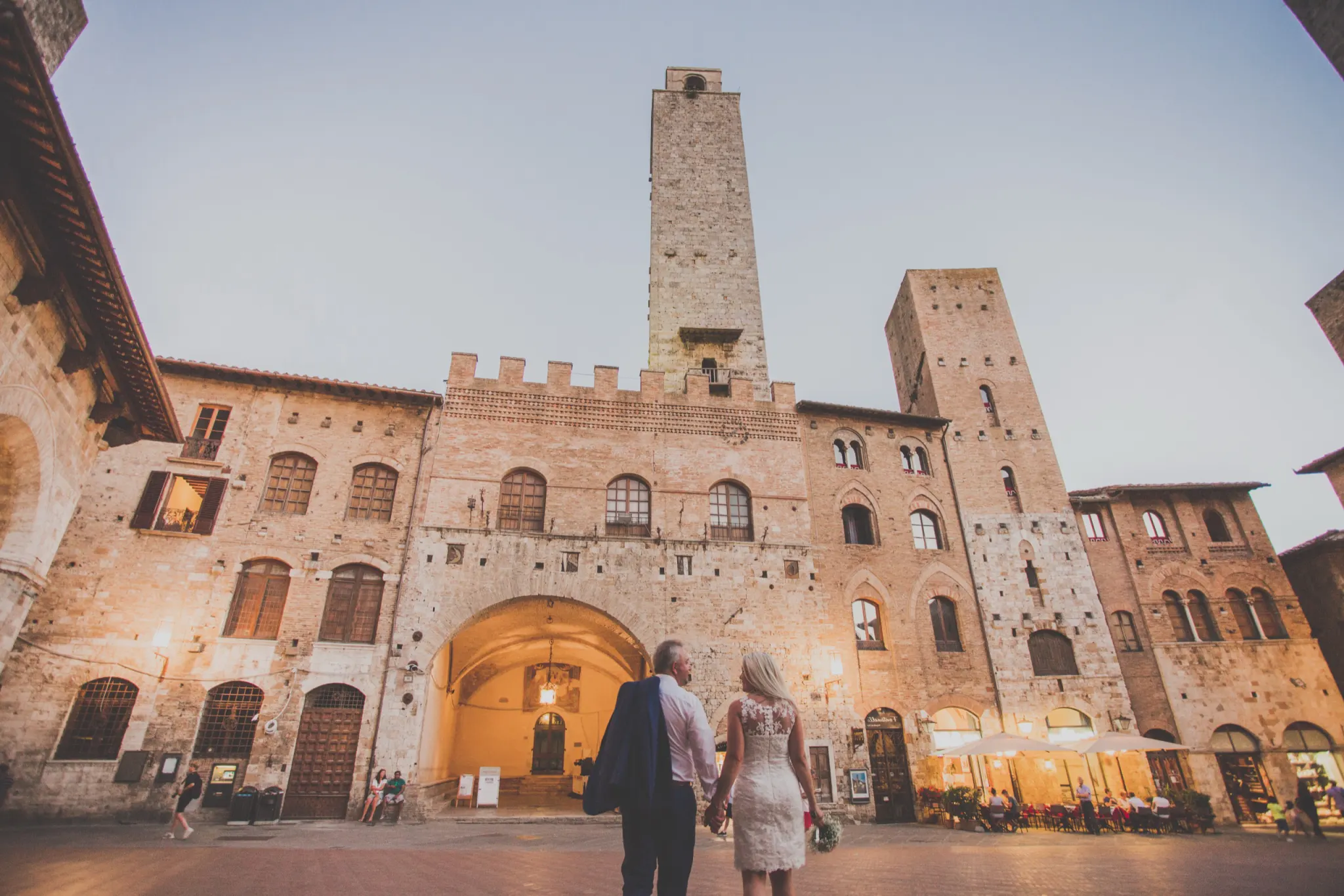 Couple walking towards the town hall of San Gimignano